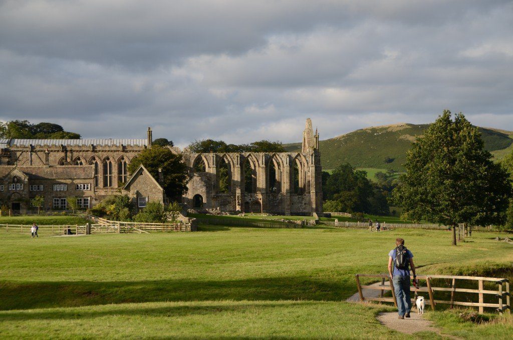 Dales Way, the ruins of Bolton Abbey, on the first day of the walk, in the late afternoon with Joel and Daisy approaching a footbridge in the foreground