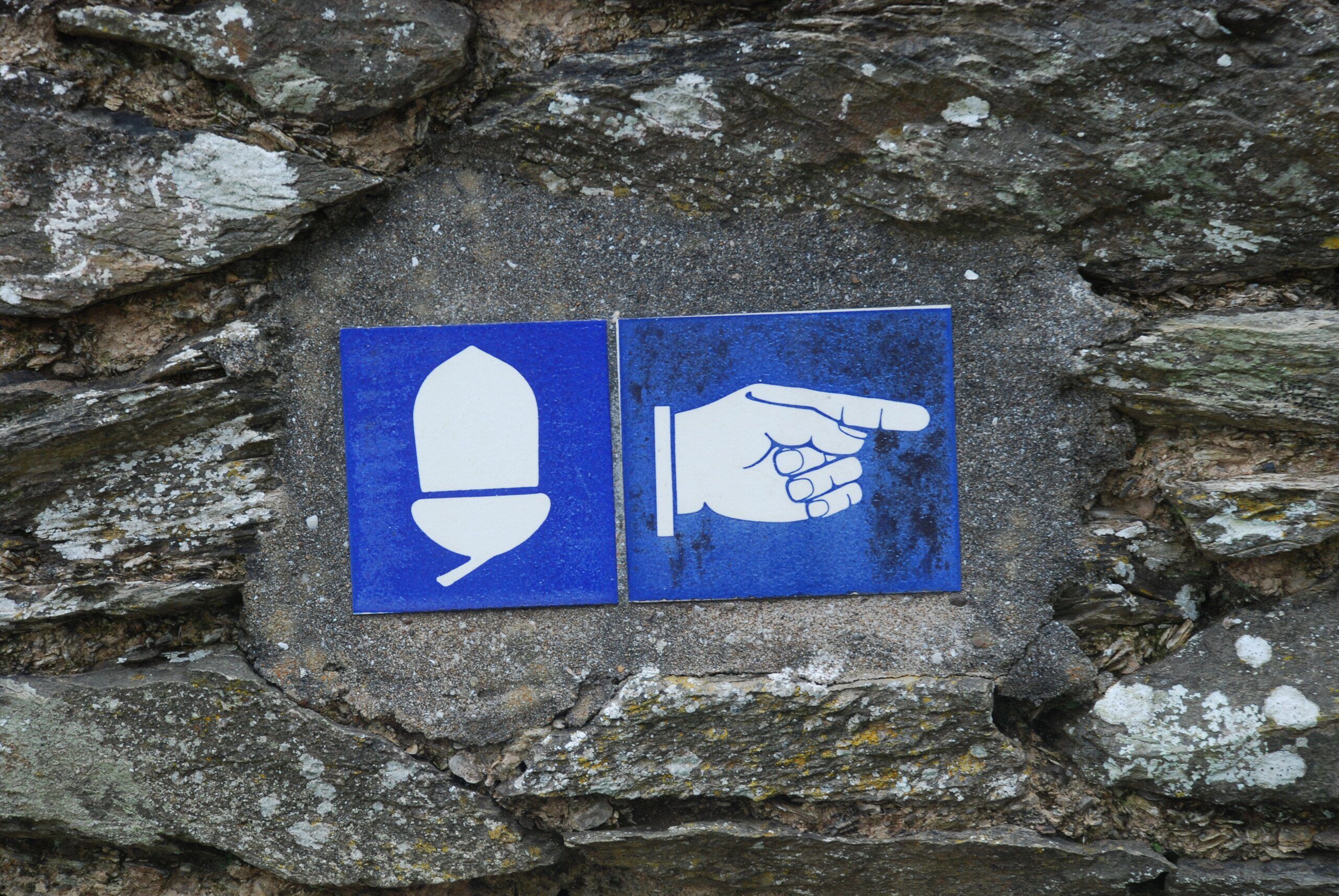 Blue ceramic National Trail sign, with acorn and hand pointing the way