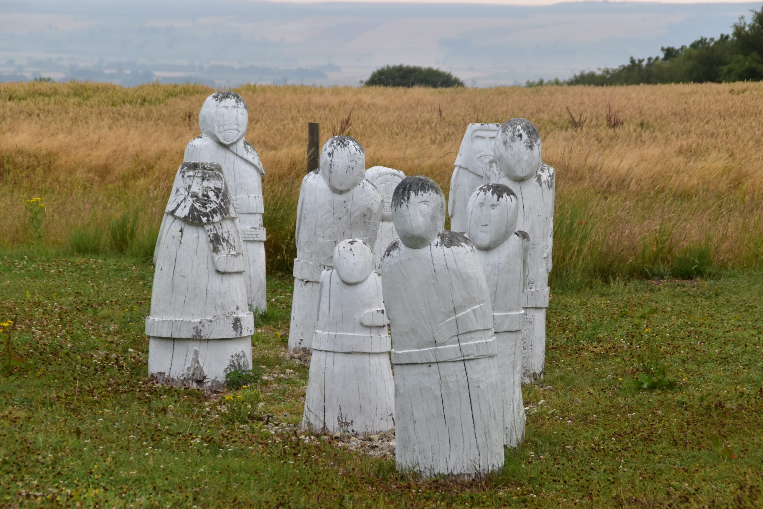 Yorkshire Wolds Way Enclosure Rites sculpture featuring eight carved white wooden figures