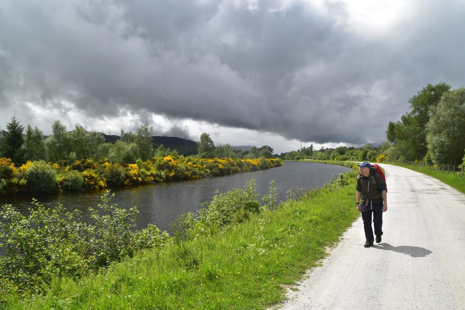 Hiker walking by the Caledonian Canal on the Great Glen Way